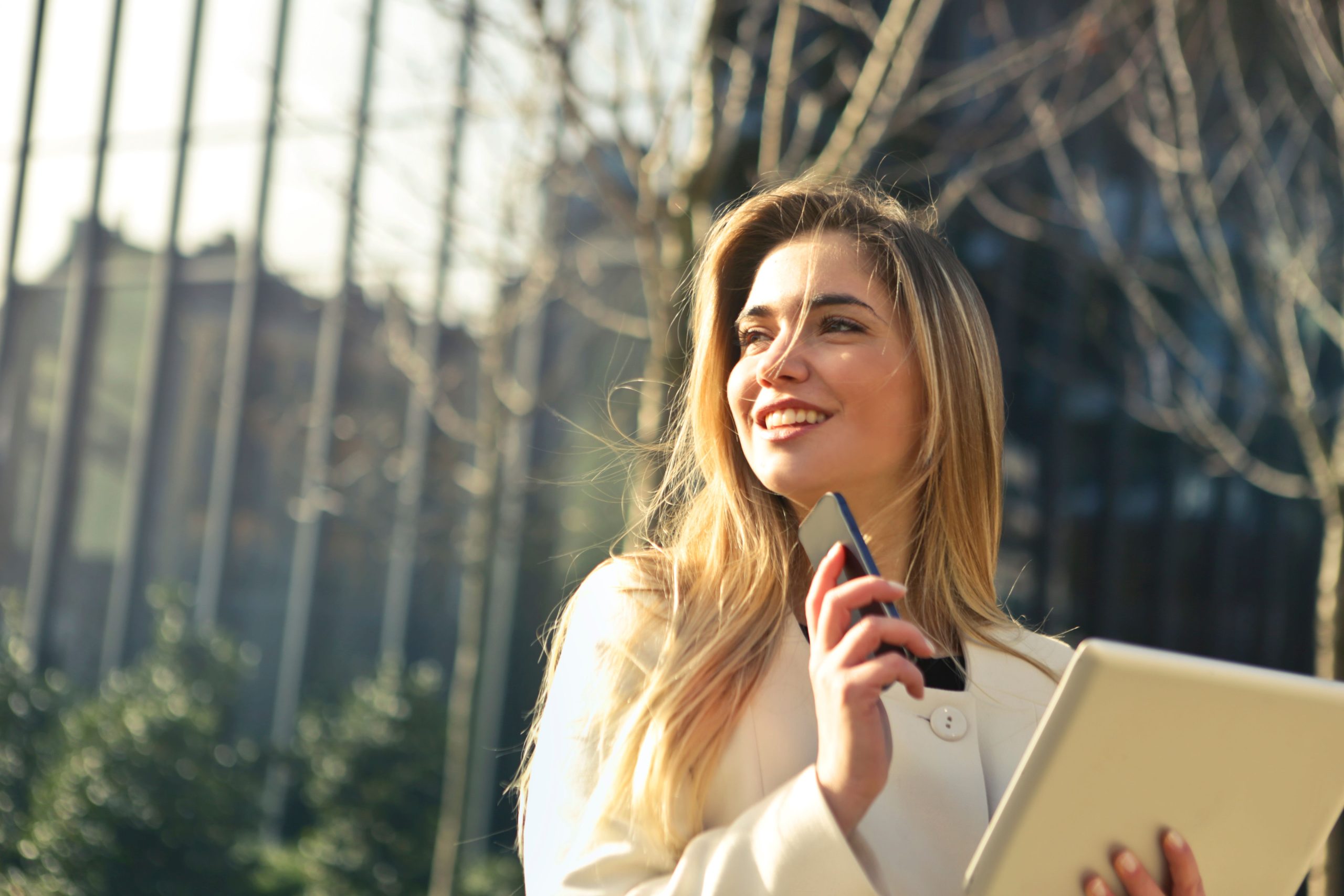 Femme d'affaires souriante avec smartphone et tablette