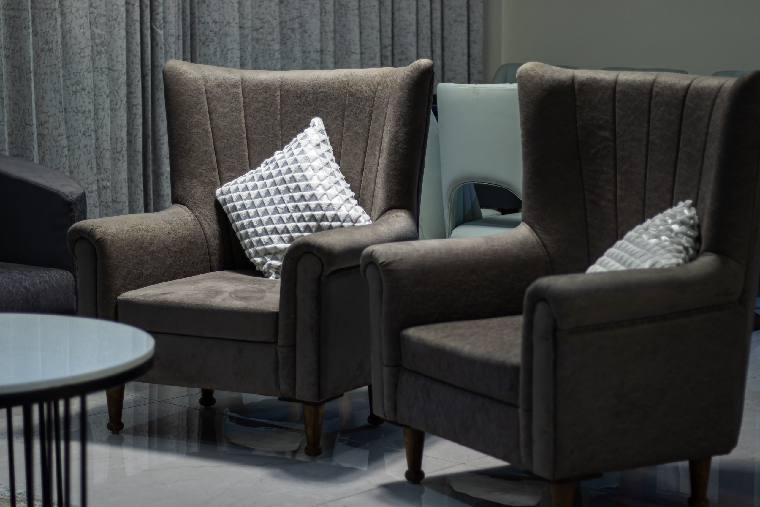 Deux fauteuils marron avec coussins decoratifs