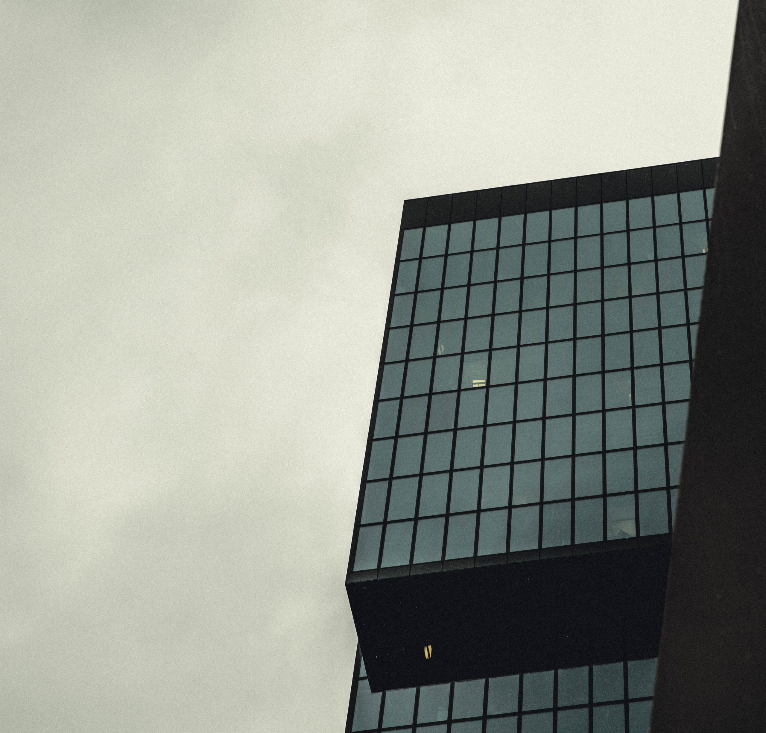 Façade vitrée immeuble contemporain ciel nuageux