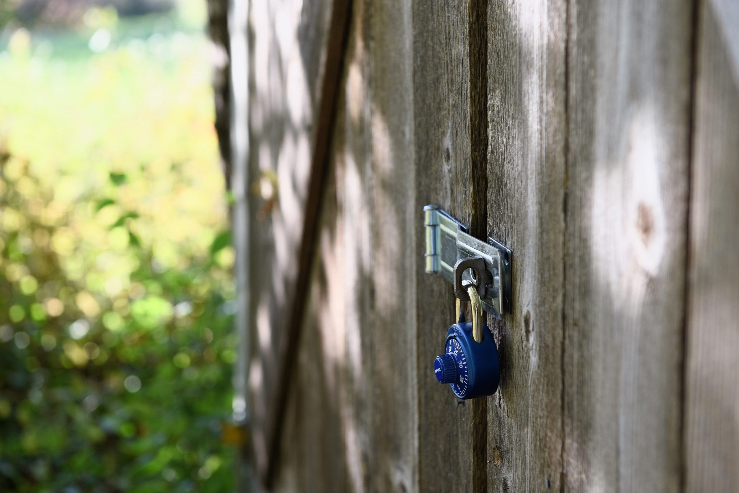 Portail en bois fermé par cadenas bleu