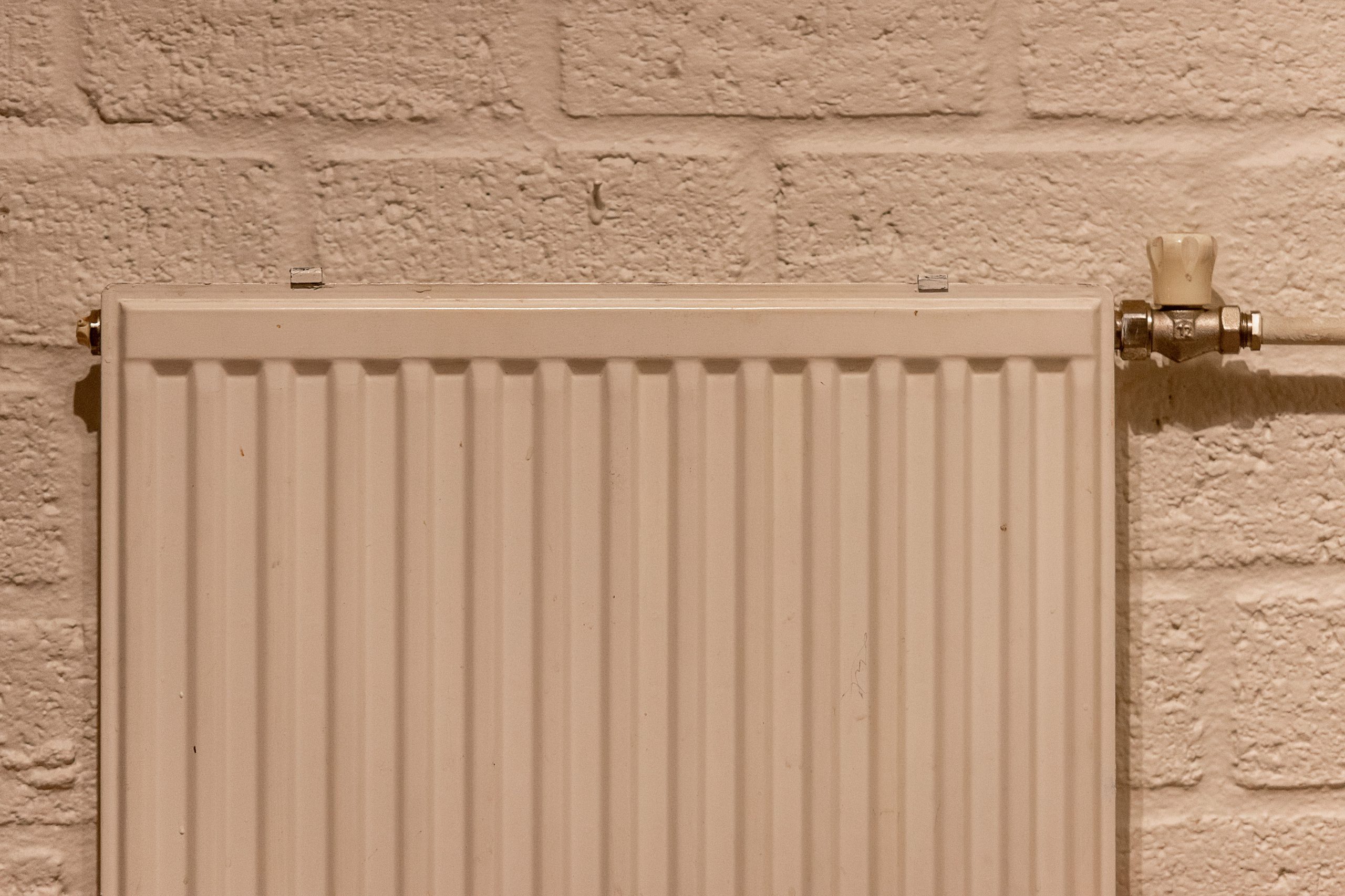Radiateur blanc sur mur en briques texturé