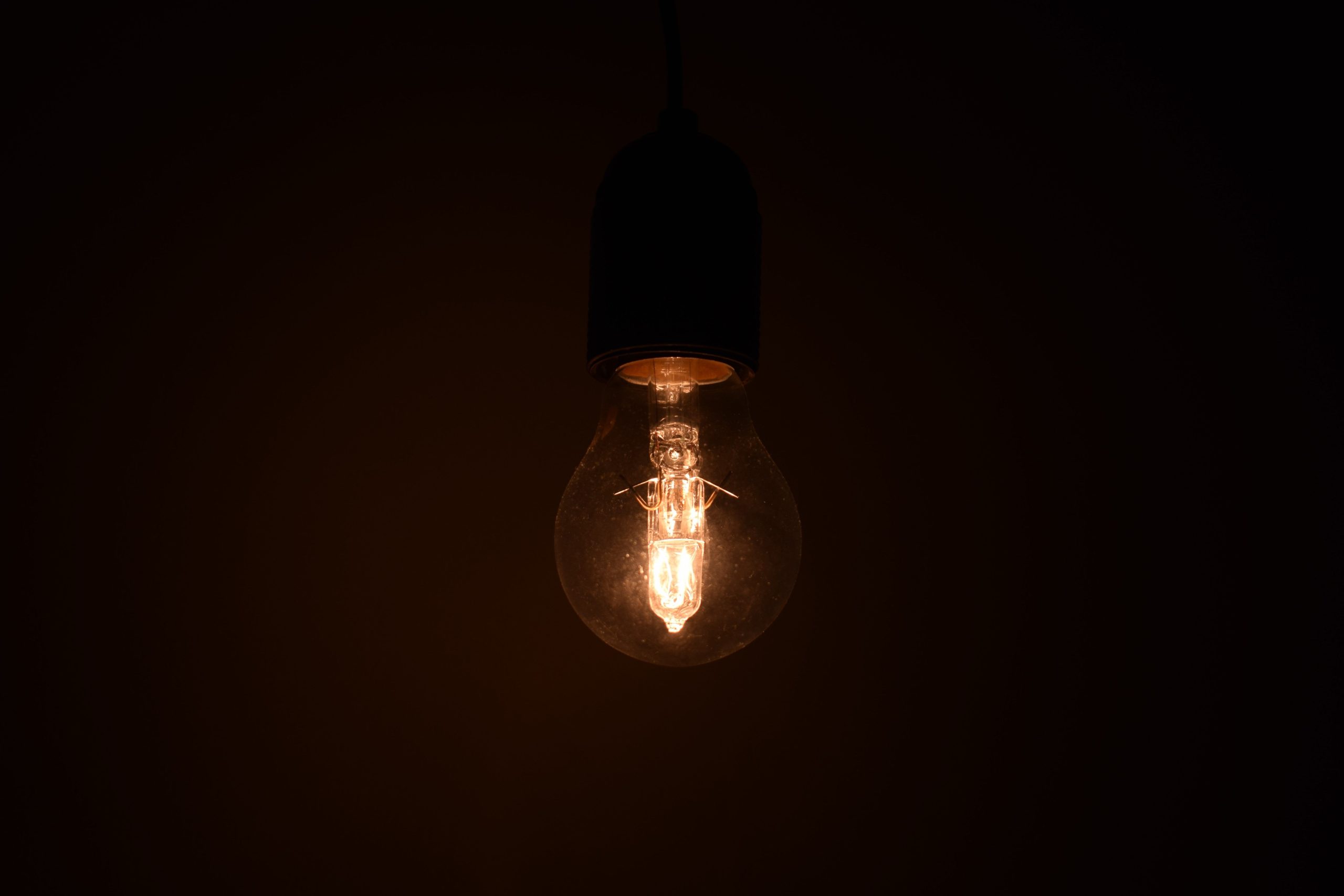 Ampoule illuminée brillant dans environnement sombre chaud