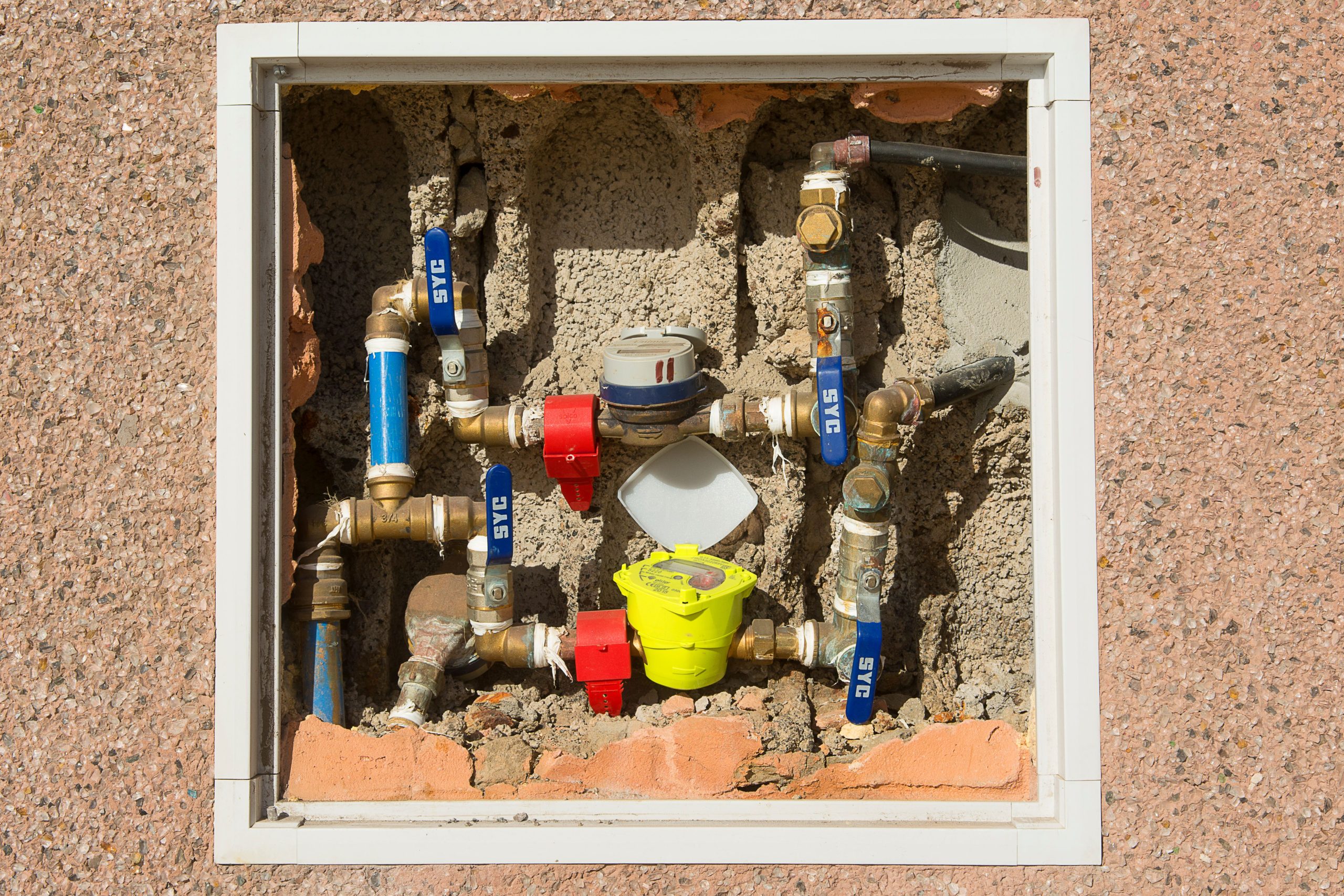 Compteur d'eau détaillé encastré dans un mur