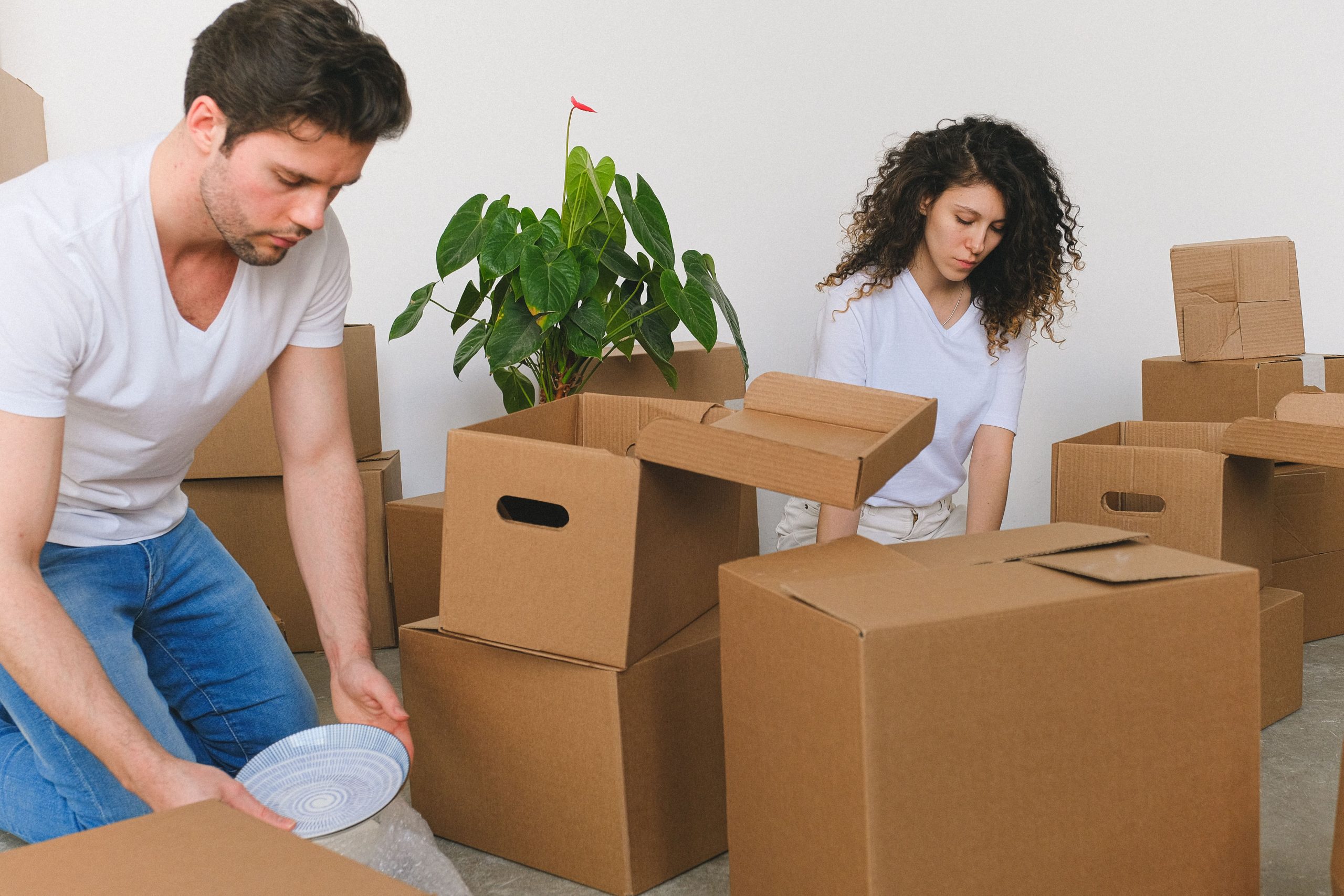 Jeune couple emballant des objets fragiles dans des cartons