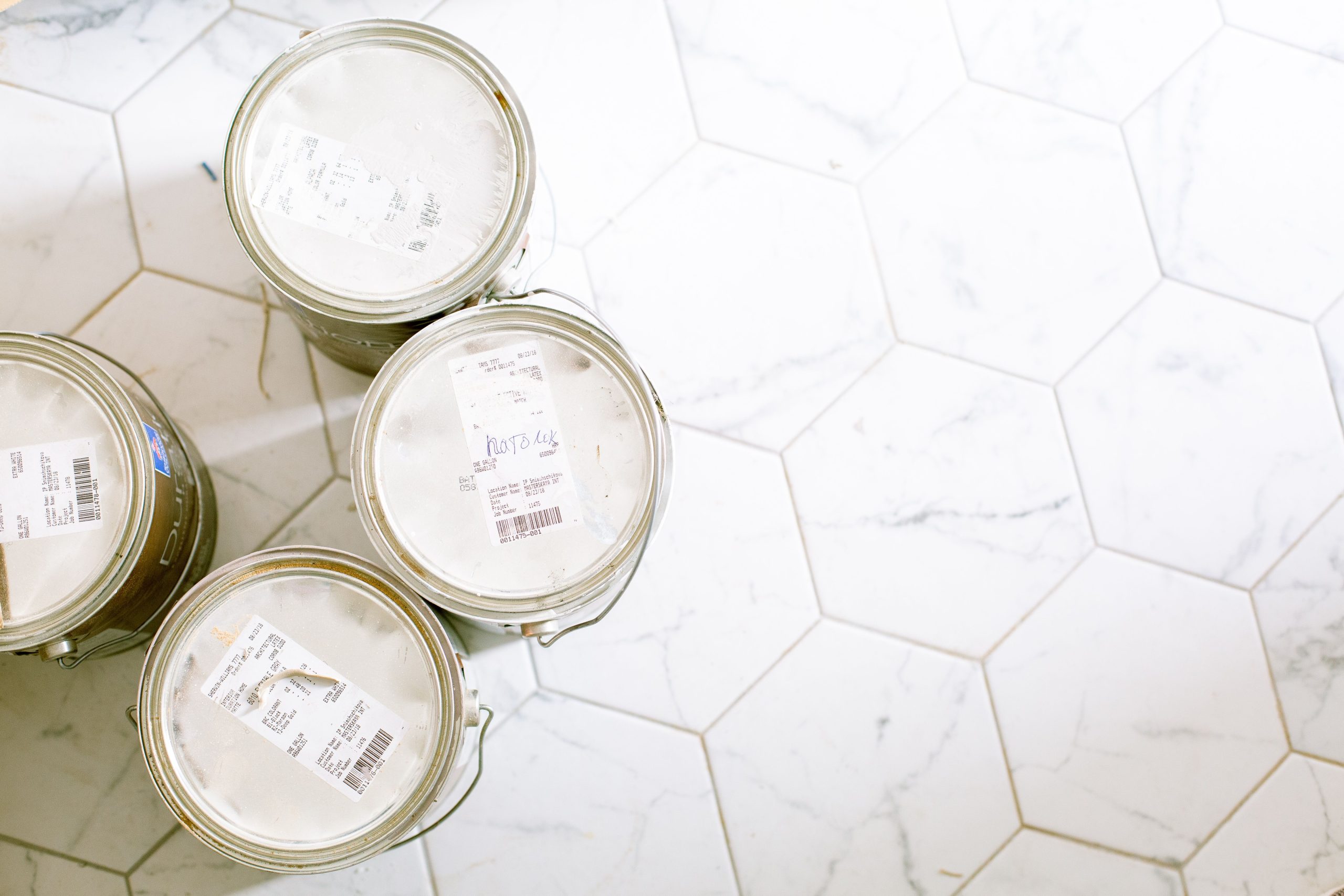 Pots de peinture sur carrelage hexagonal rénové