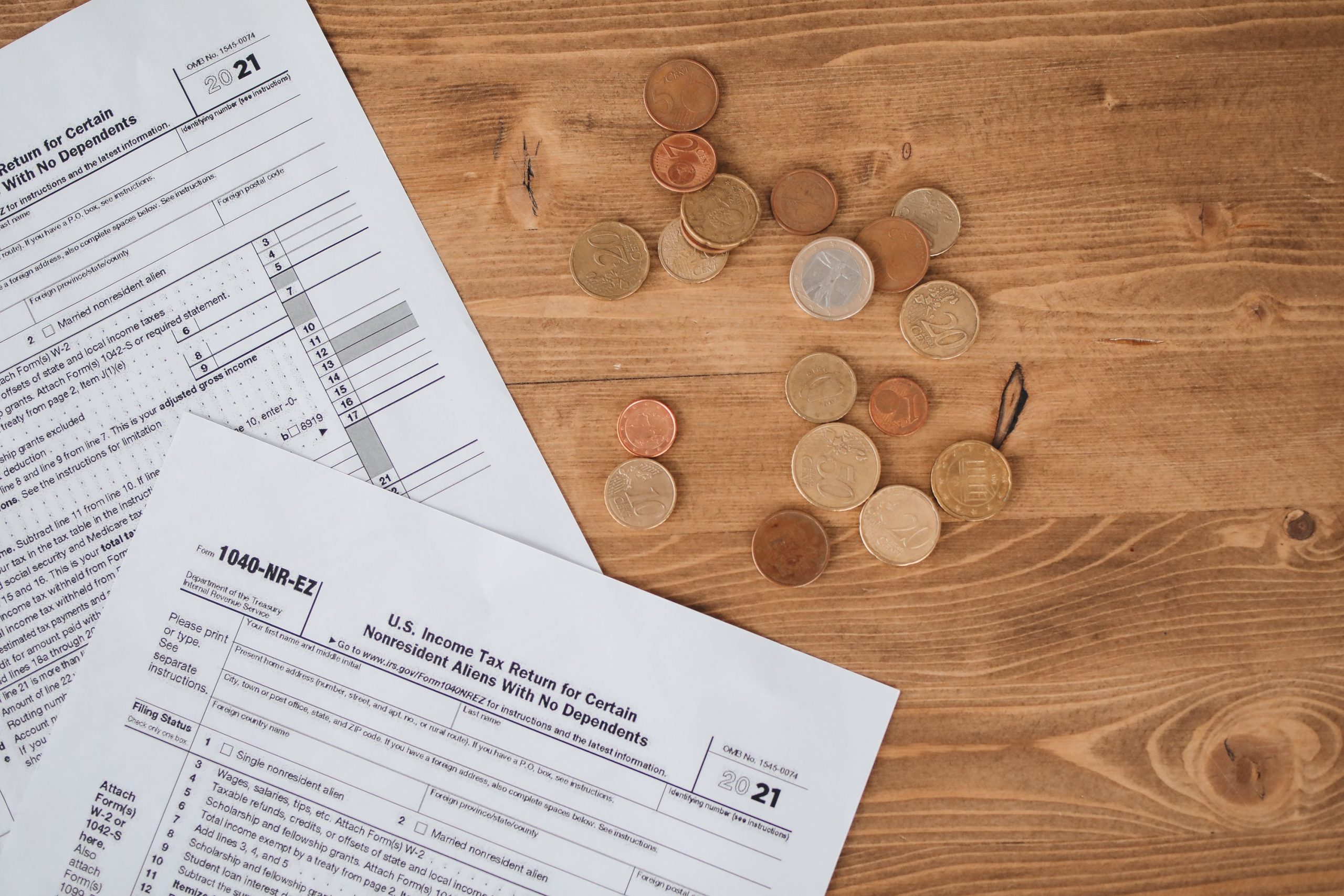 Formulaires fiscaux et pièces de monnaie sur table en bois