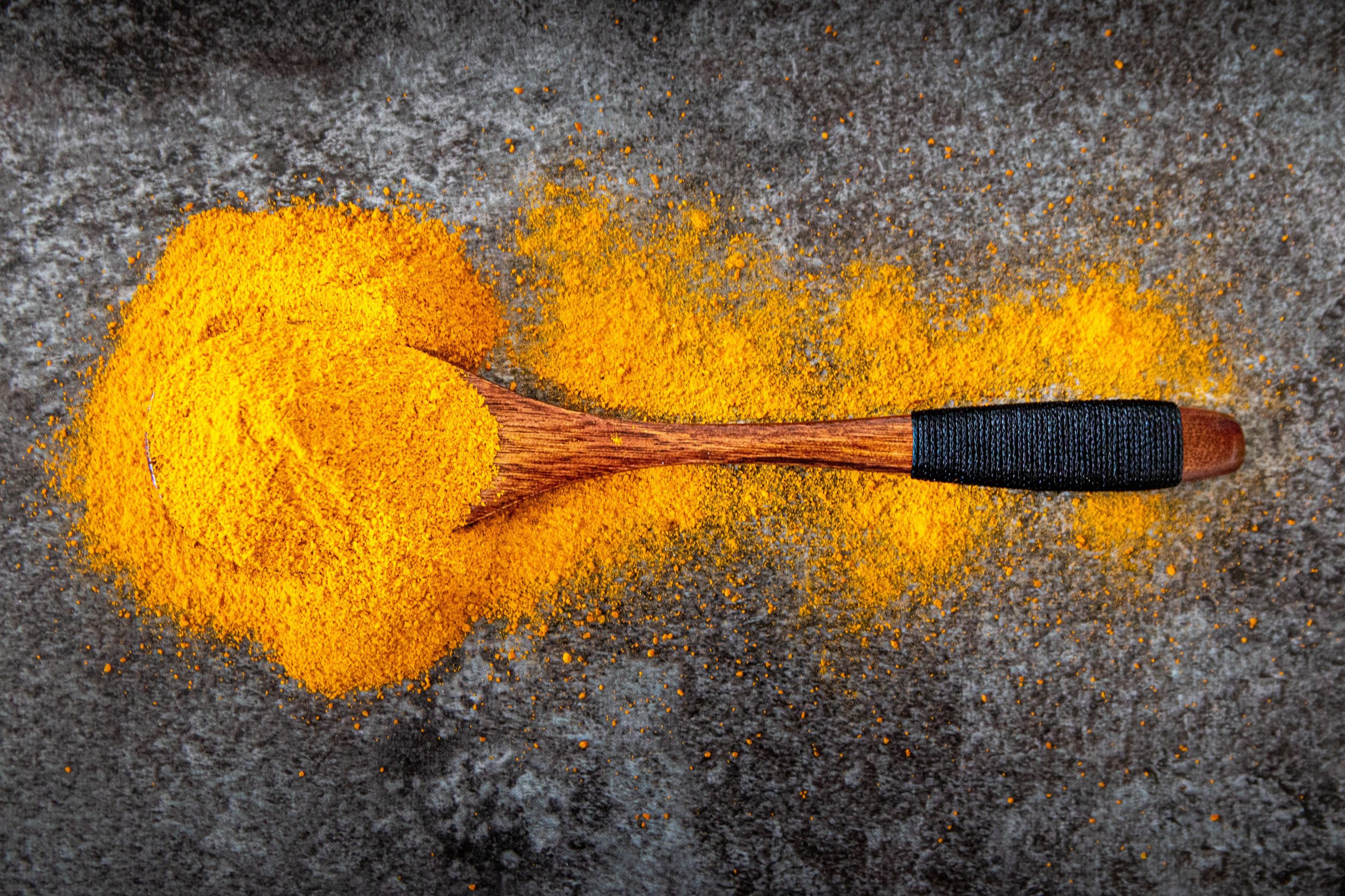 Poudre de curcuma vive avec cuillère en bois
