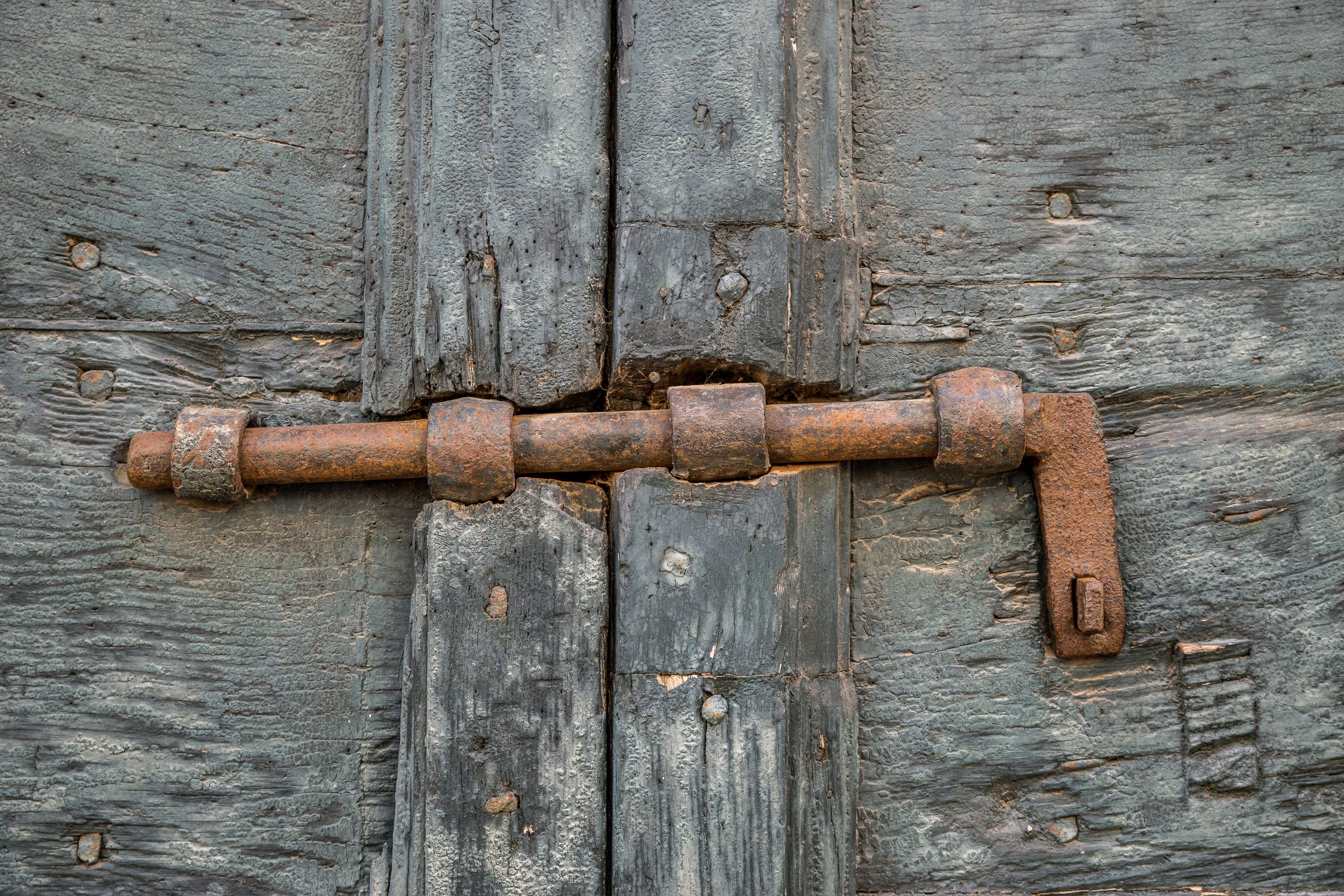 Verrou en fer corrodé sur une porte en bois